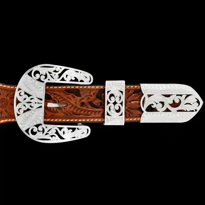 A custom western three piece belt buckle set featuring silver filigrane 